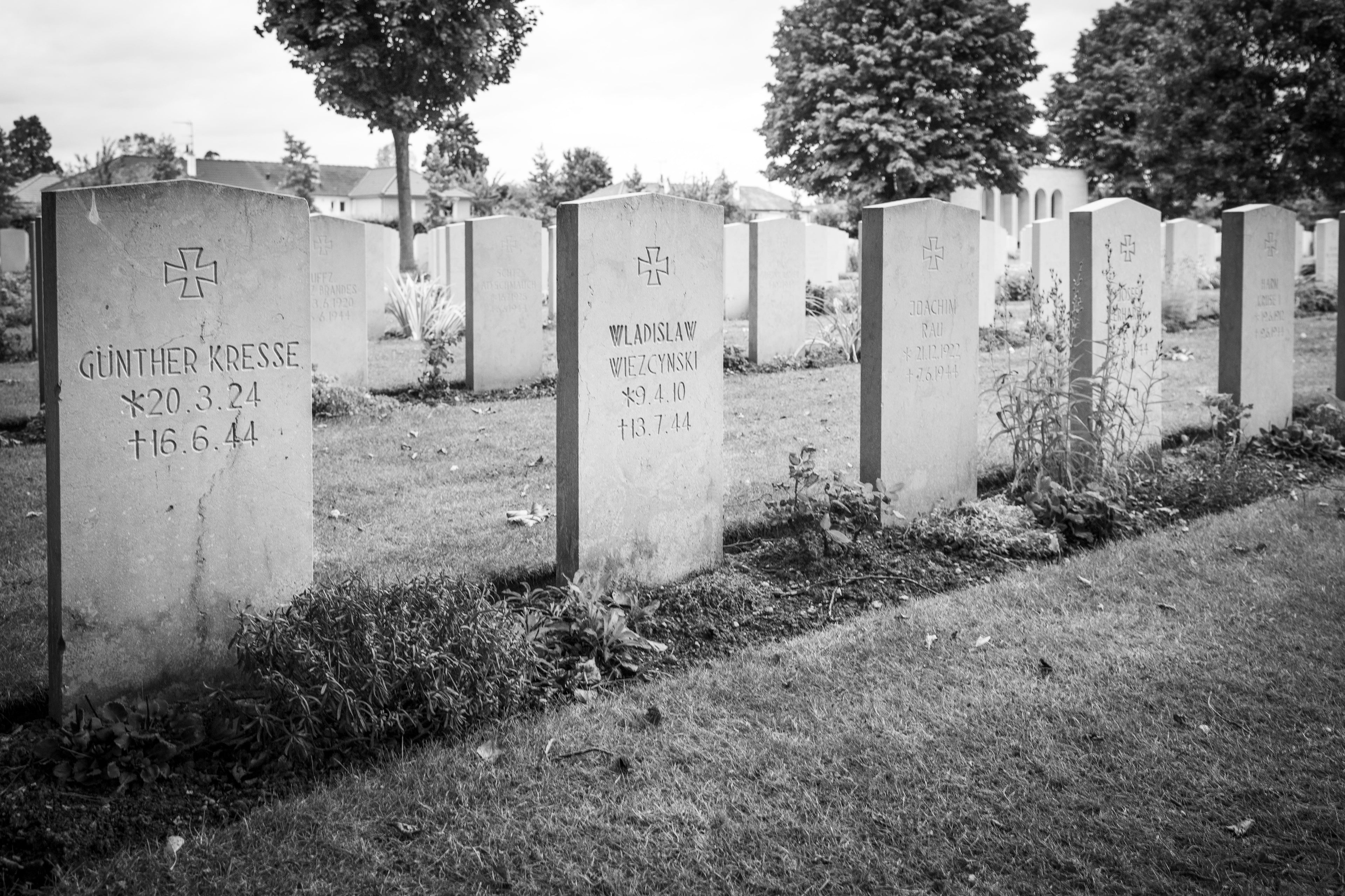 German headstones with iron crosses standing in the rows among Commonwealth graves, Ranville War Cemetery, Normandy