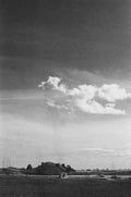 The church on the hill above Alnmouth under heavy weather, the village below it, black and white