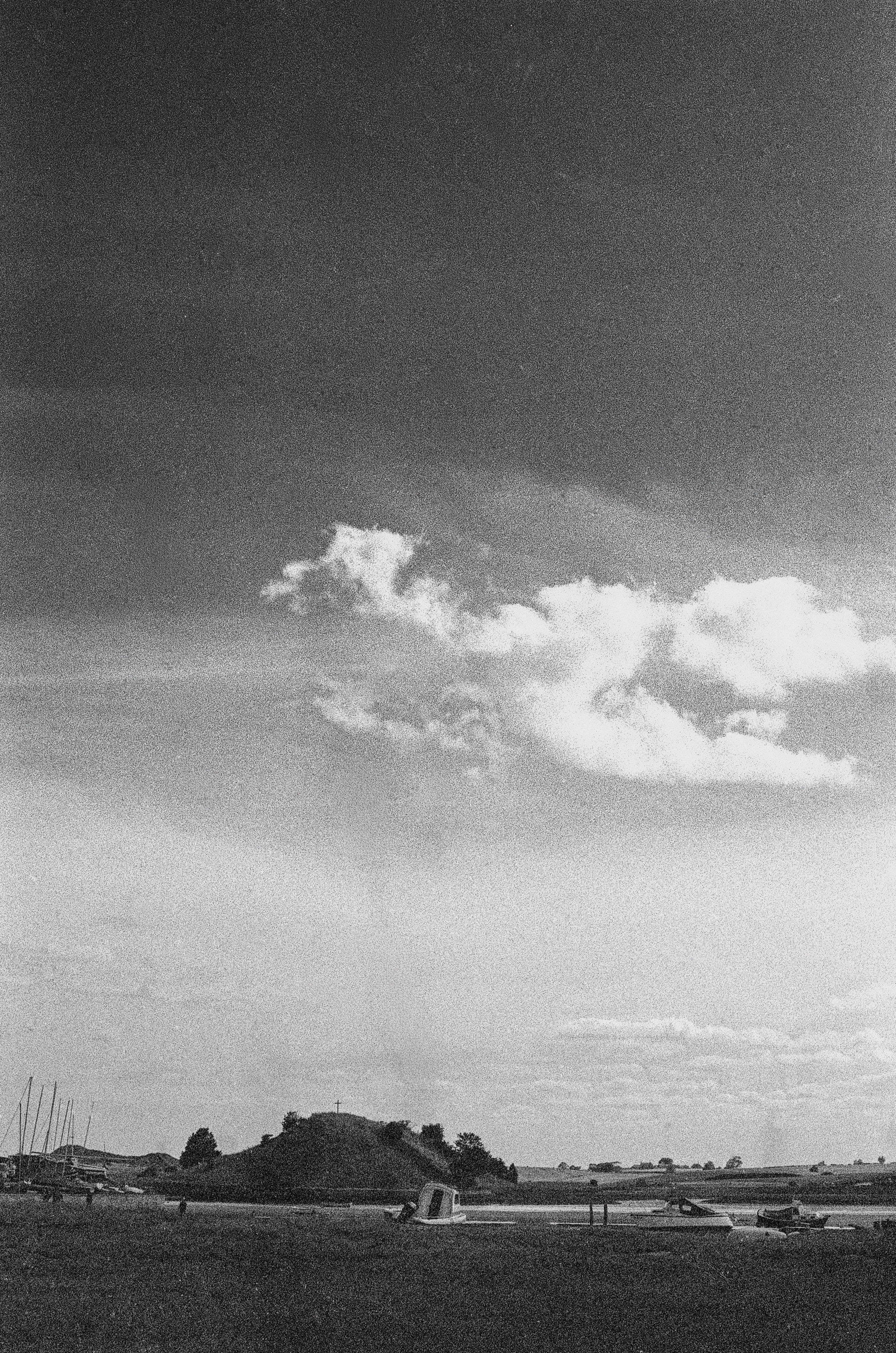 The church on the hill above Alnmouth under heavy weather, the village below it, black and white