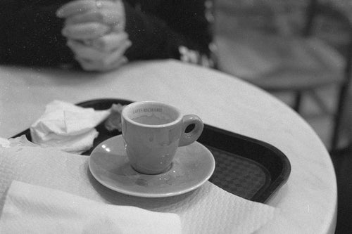 Empty Cafés Richard espresso cup on a café table in Nantes — Nikon FE, Rollei RPX 400